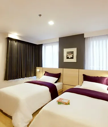 Hotel accommodation with 2 single beds, decorated in Cream and Burgundy.