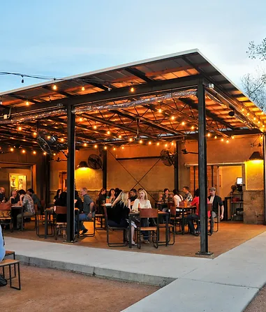 RODE Outdoor eating area with tables and people laughing.